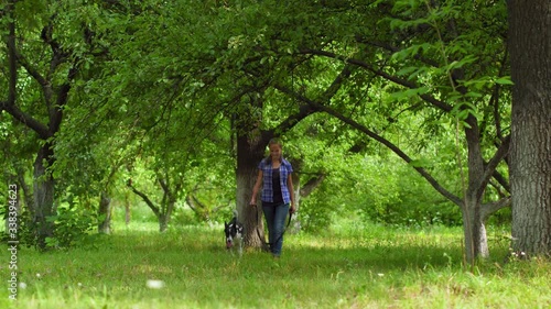 Teenage owner walke hed doge in a park or back yard photo