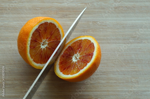 Splitting an orange into two pieces photo