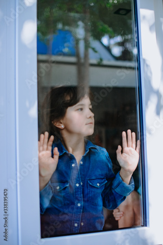 young girl looking out from the window