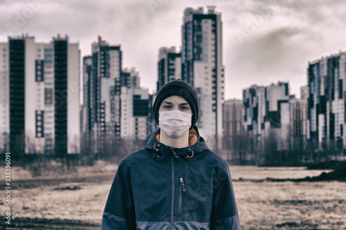 teen wearing a medical mask against the background of a city against quarantine photo