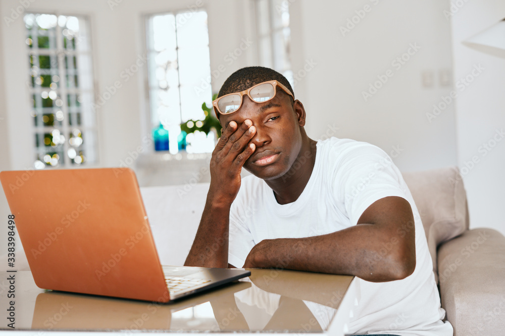 man of african appearance at home in front of a laptop man of african appearance at home in front of a laptop