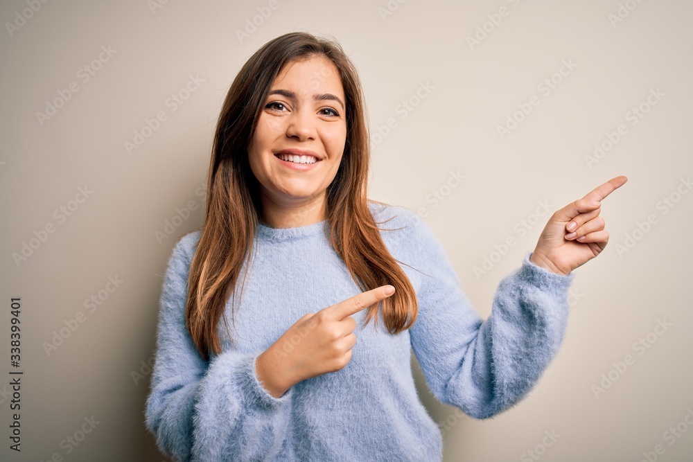 Beautiful young woman wearing casual winter sweater standing over isolated background smiling and looking at the camera pointing with two hands and fingers to the side. Beautiful young woman wearing casual winter sweater standing over isolated background smiling and looking at the camera pointing with two hands and fingers to the side.