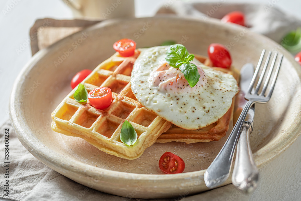 Closeup of homemade waffles with fried eggs and cherry tomatoes