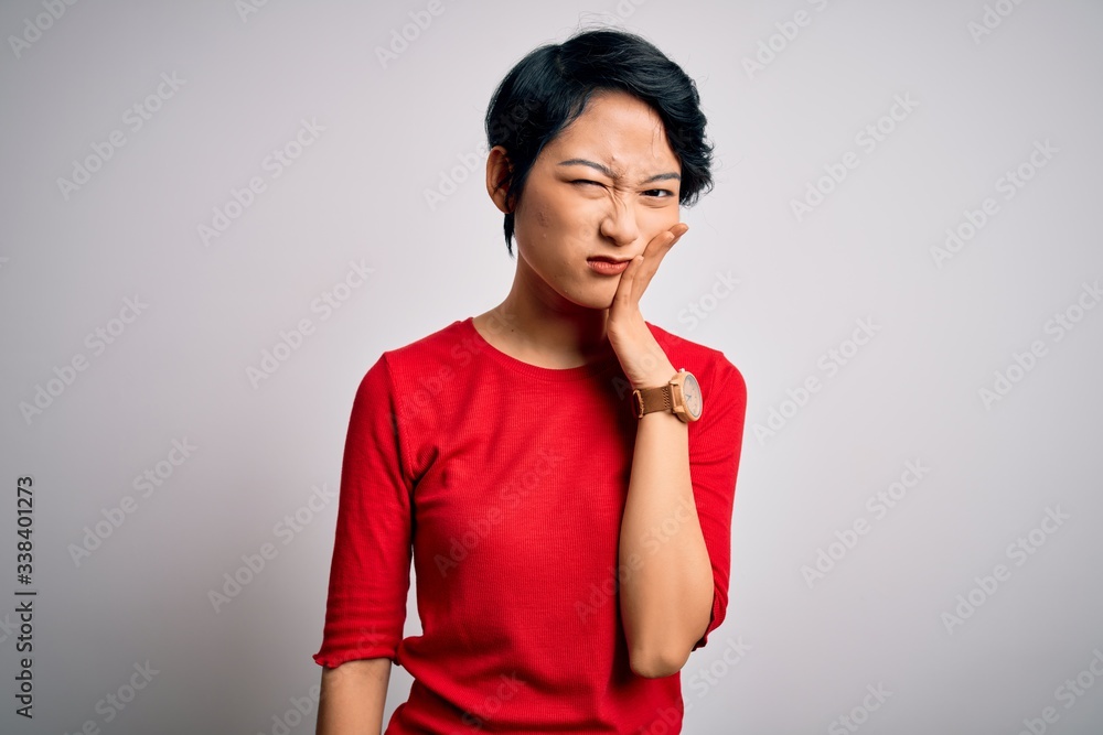 Young beautiful asian girl wearing casual red t-shirt standing over isolated white background thinking looking tired and bored with depression problems with crossed arms. Young beautiful asian girl wearing casual red t-shirt standing over isolated white background thinking looking tired and bored with depression problems with crossed arms.