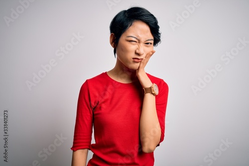 Young beautiful asian girl wearing casual red t-shirt standing over isolated white background thinking looking tired and bored with depression problems with crossed arms.