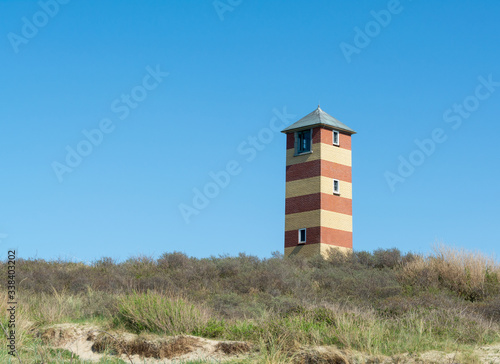 Lighthouse on the coast in Dishoek Zeeland in the Netherlands with blue sky photo