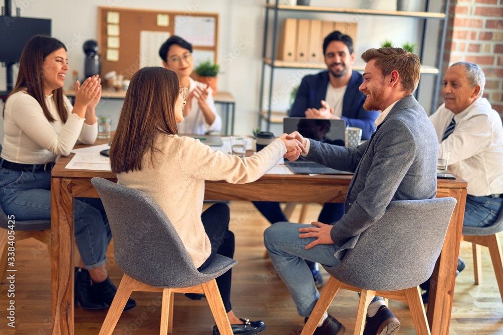 Group of business workers smiling happy and confident. Working together with smile on face shaking hands at the office Group of business workers smiling happy and confident. Working together with smile on face shaking hands at the office