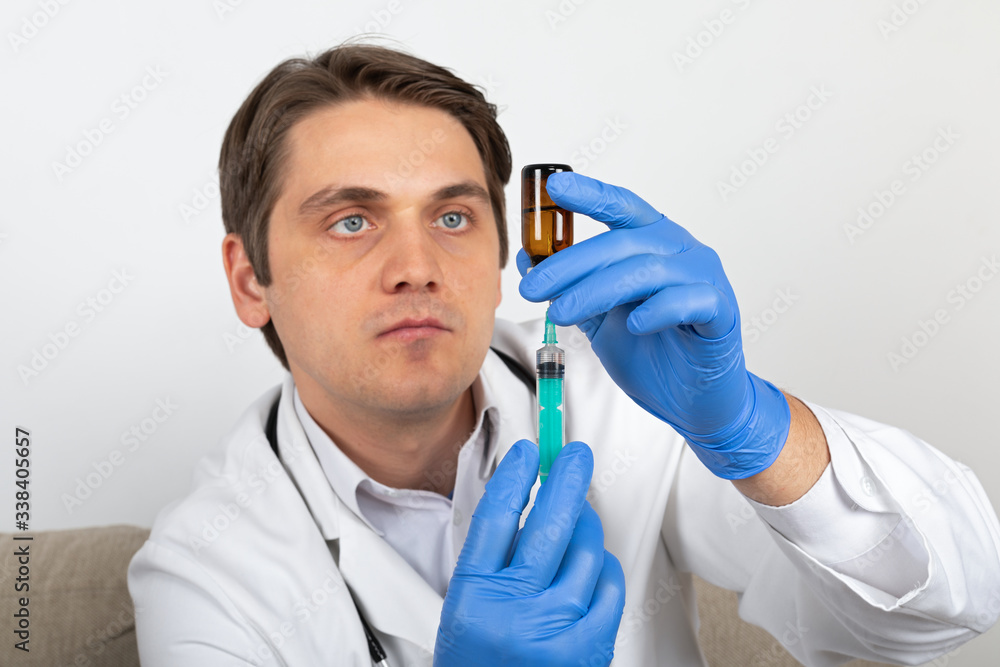 Doctor holding liquid medication and syringe Doctor holding liquid medication and syringe