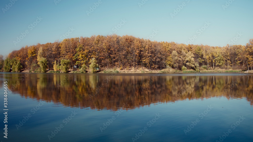 Autumn landscape, yellow trees are reflected on the surface of the lake. Autumn landscape, yellow trees are reflected on the surface of the lake.