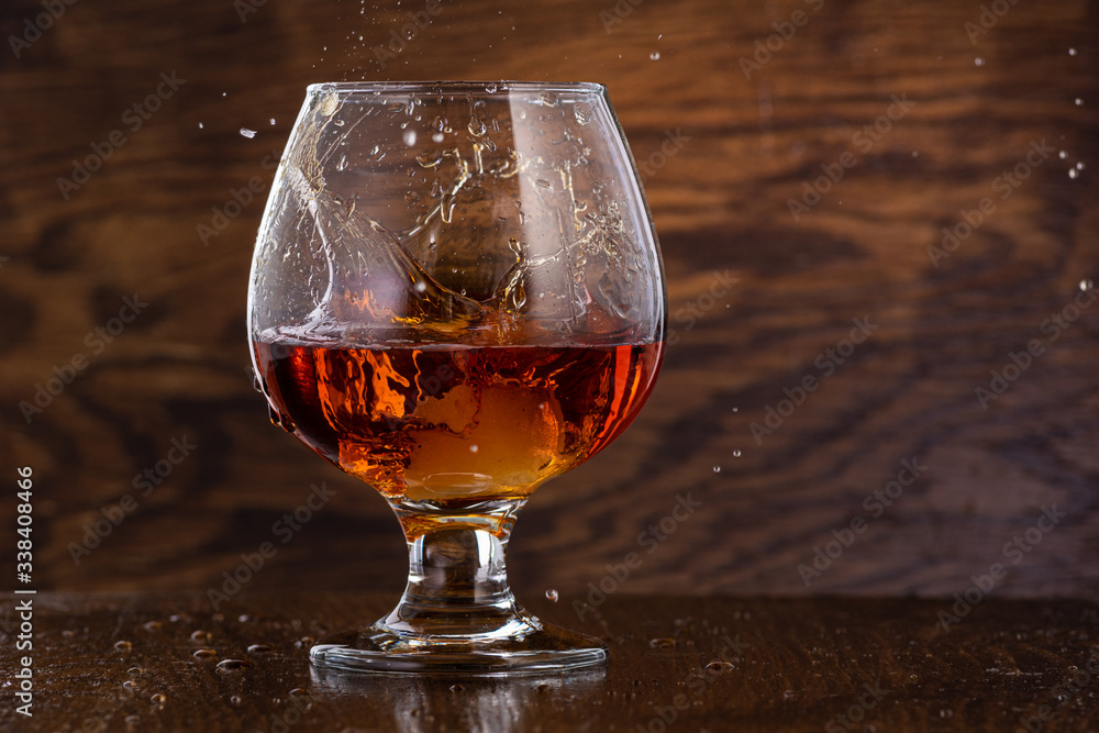 Splash in cognac glass from falling ice Splash in cognac glass from falling ice