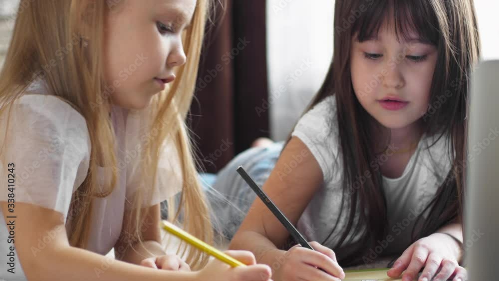 Two girls paint at home on the floor