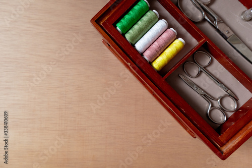 Composition of sewing box in wooden background. Top view  flat lay  copy space