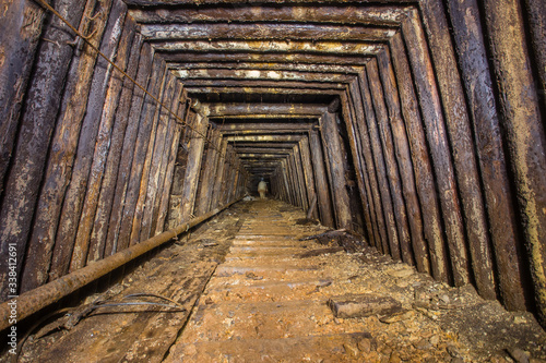 Underground abandoned bauxite ore mine tunnel with wooden timbering © Mishainik