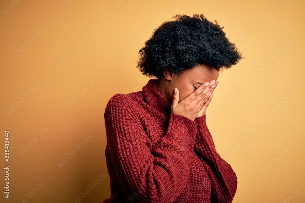 Young beautiful African American afro woman with curly hair wearing casual turtleneck sweater with sad expression covering face with hands while crying. Depression concept. Young beautiful African American afro woman with curly hair wearing casual turtleneck sweater with sad expression covering face with hands while crying. Depression concept.