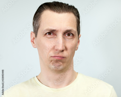Portrait of a discouraged man, grey background, emotions series