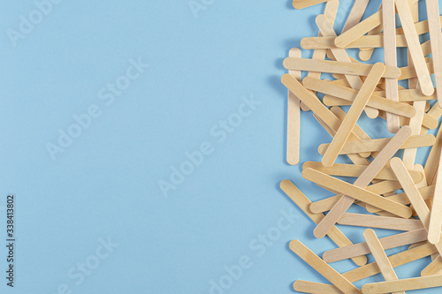 Wooden ice cream stick on blue background. a pile of the wooden sticks. popsicle stick