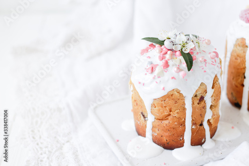 Selective focus Easter Orthodox sweet bread, Easter cakes decorated with flowers and sweets on a white marble plate on a white wooden background. Holidays breakfast concept with copy space.close-up