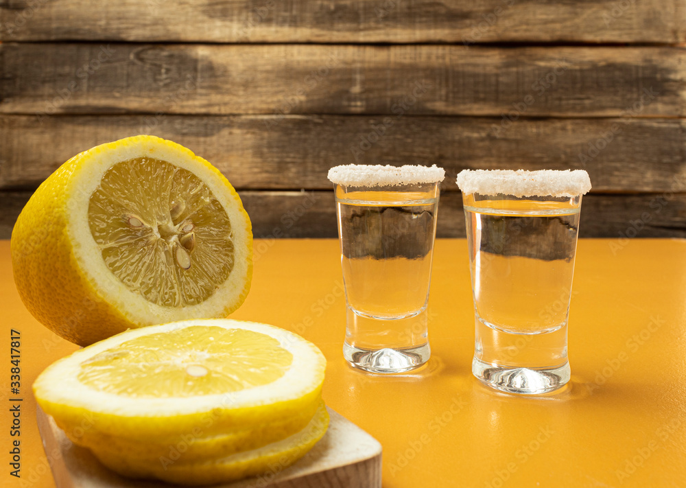 Tequila, salt and lemon on a yellow background Tequila, salt and lemon on a yellow background