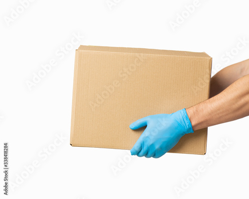Courier presents cardboard box in rubber gloves