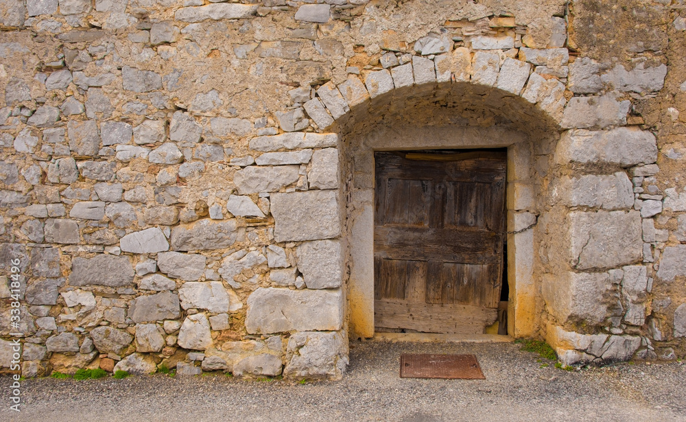 An old wooden door in a derelict building in the historic hill village of Stanjel in the Komen municipality of Primorska, south west Slovenia.
