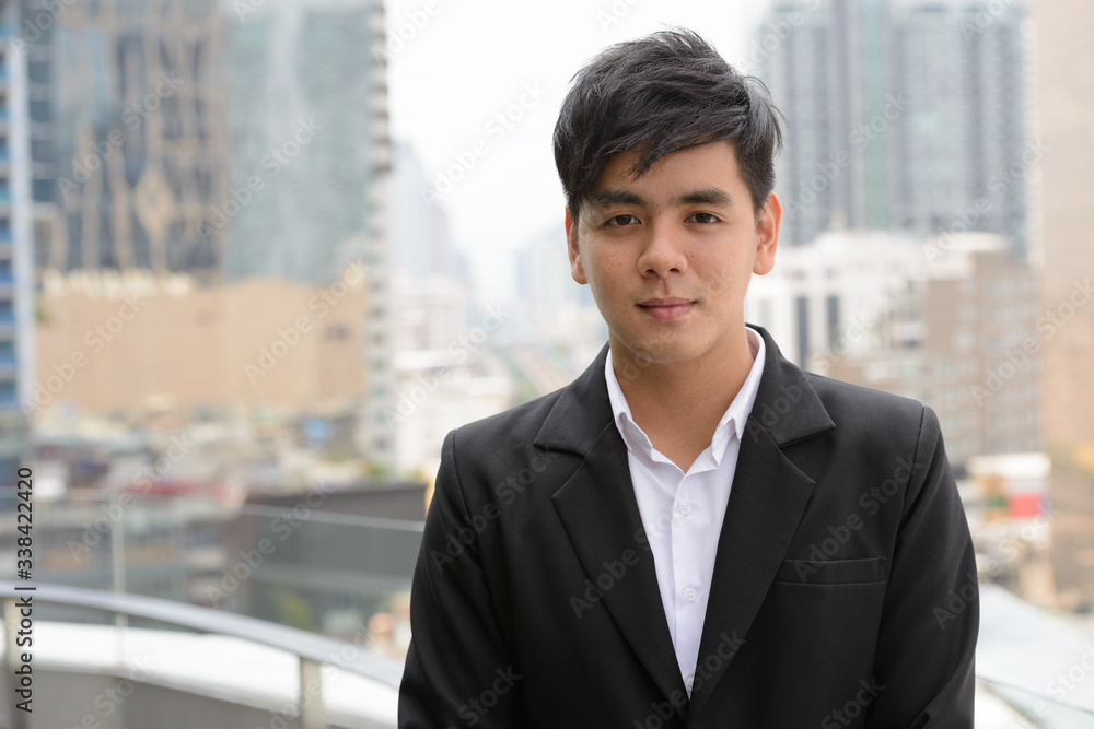 Face of young handsome Asian businessman in the city Face of young handsome Asian businessman in the city