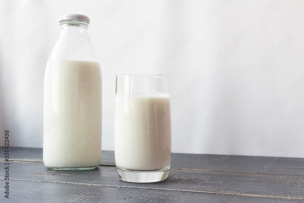 Fermented dairy products. Milk, kefir in a glass bottle and a glass. Farm rustic drinks on a gray wooden background. Fermented dairy products. Milk, kefir in a glass bottle and a glass. Farm rustic drinks on a gray wooden background.
