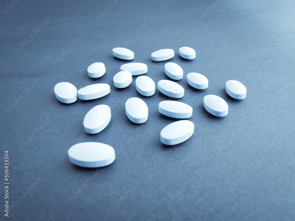 generic white pills on grey backdrop generic white pills on grey backdrop