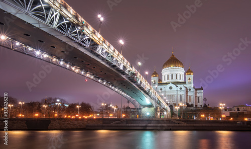 The Cathedral of Christ the Saviour or Savior and Patriarchal pedestrian bridge with night illumination in the evening in Moscow, Russia. Russian Orthodox church on the Moskva river © mitzo_bs