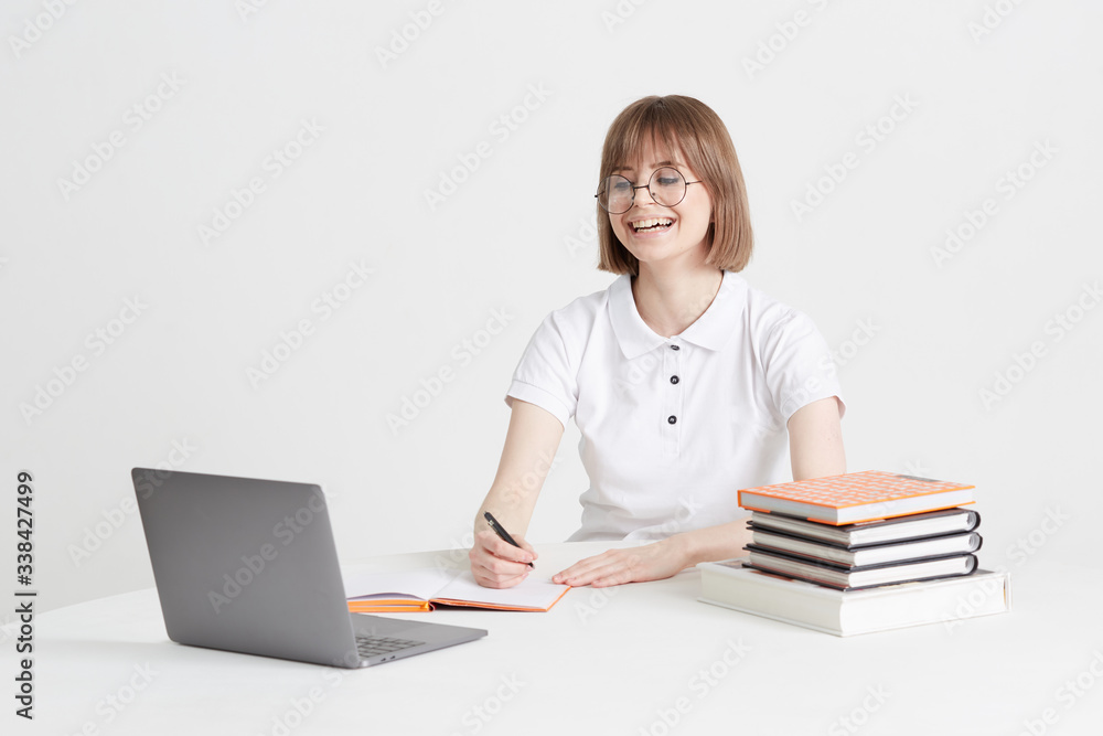 Cool happy girl goes through online training sitting at home. Remote school education on a laptop. Stay home lessons. Cool happy girl goes through online training sitting at home. Remote school education on a laptop. Stay home lessons.