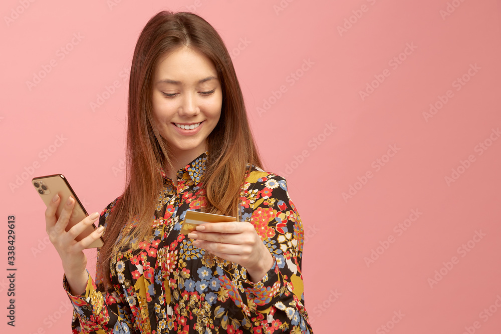 Girl gets banking service, an online purchase, using a credit card with a student offer, holds a mobile phone in hands. Girl gets banking service, an online purchase, using a credit card with a student offer, holds a mobile phone in hands.