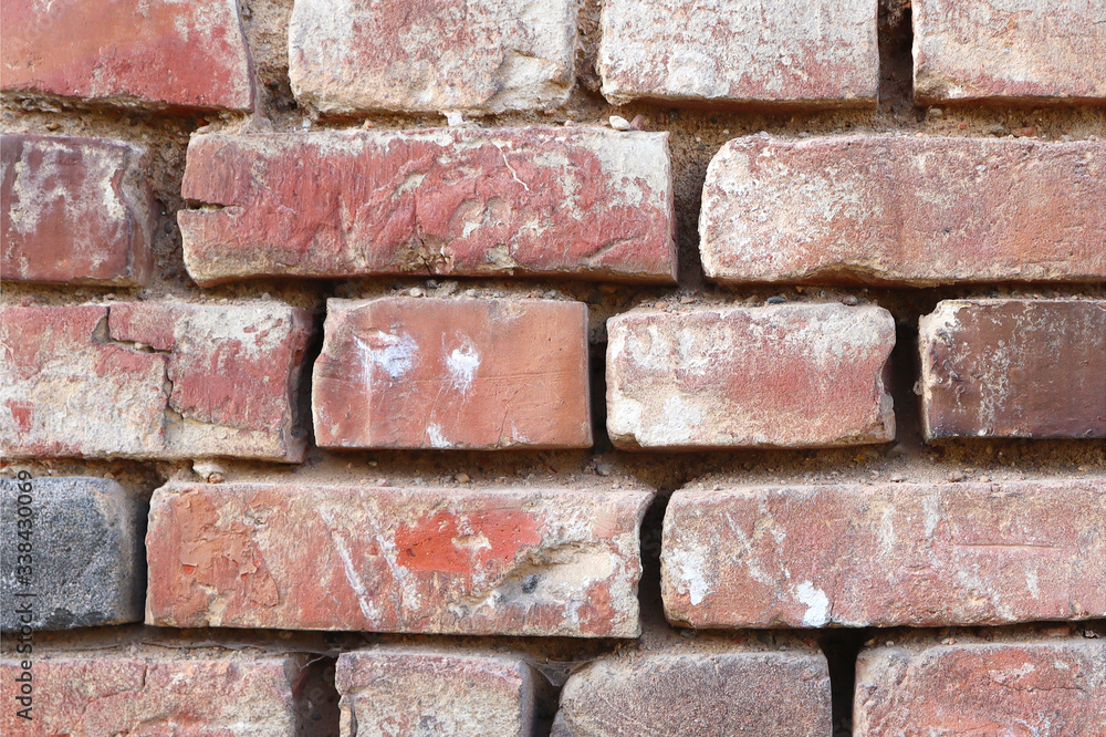 Fototapeta premium Red brick wall with cracks and scratches. Old background texture. Vintage house facade.