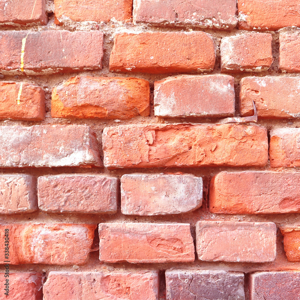 Obraz premium Red brick wall with cracks and scratches. Old background texture. Vintage house facade.
