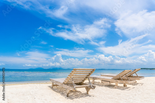 White beach chair on white sand beach.