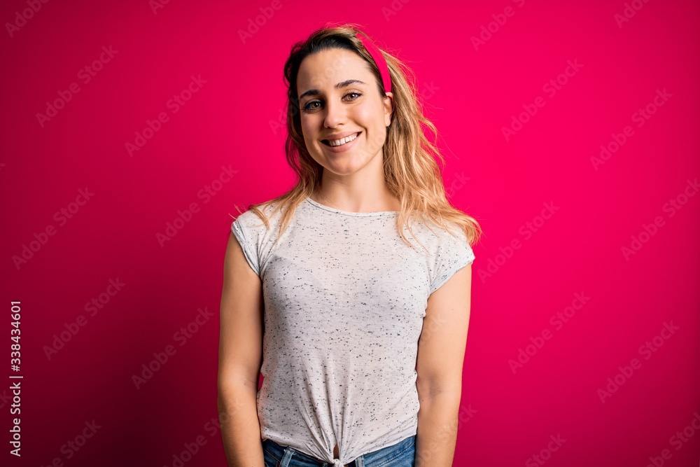 Young beautiful blonde woman wearing casual t-shirt standing over isolated pink background with a happy and cool smile on face. Lucky person. Young beautiful blonde woman wearing casual t-shirt standing over isolated pink background with a happy and cool smile on face. Lucky person.