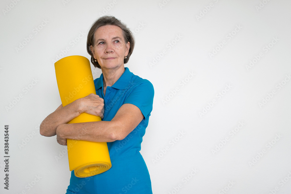 healthy white fit smiling happy senior woman stand and hold mat in hands, life is good healthy white fit smiling happy senior woman stand and hold mat in hands, life is good