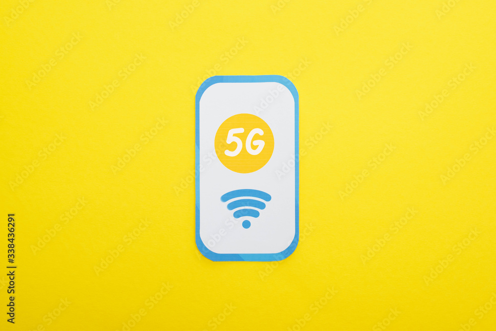 top view of 5g lettering on paper smartphone on yellow background top view of 5g lettering on paper smartphone on yellow background