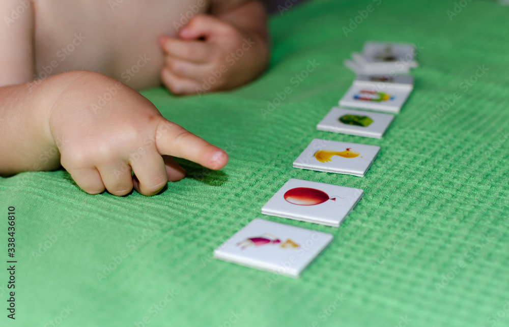 Child lining up toys on the floor at home. Kids education concept.