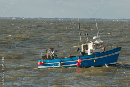 Marin pêcheur à bord de son bateau de pêche au travail pour relever ses filets, ses nasses, ses casiers et qui profite de la marée qui monte pour rapporter du poisson des crabes des homards et araigné