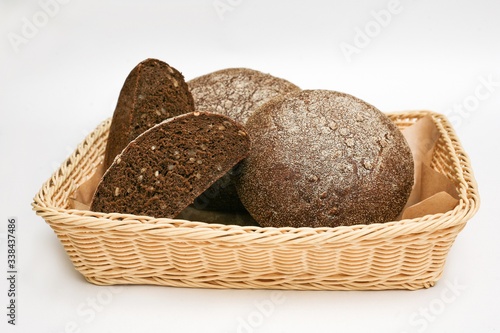 black bread with sunflower seeds in a basket white background