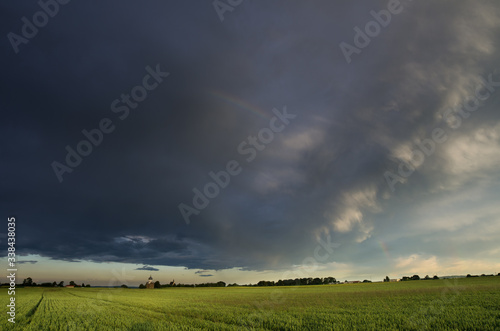 storm clouds over rural green spring fields