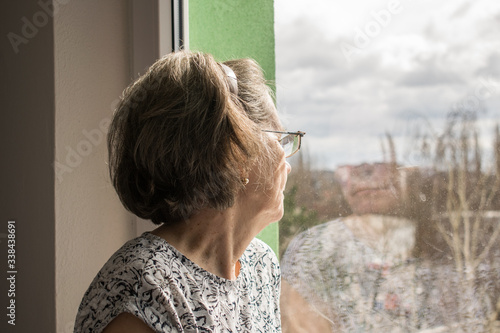  sad lonely old woman look next to window allone depressed abandoned coronavirus stay home 