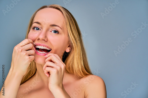 Close up glad girl cleaning her teeth by toothpick. Dental concept