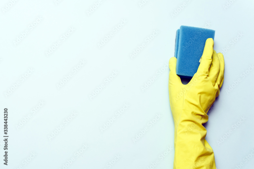 yellow rubber glove is holding sponge on the white background. yellow rubber glove is cleaning with sponge yellow rubber glove is holding sponge on the white background. yellow rubber glove is cleaning with sponge
