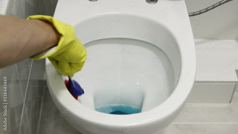 Cleaning White Toilet with brush in yellow gloves. White Cleaning White Toilet with brush in yellow gloves. White