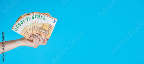 Fifty Euro Banknotes in Hand on blue background. Euro Money, Euro Cash.