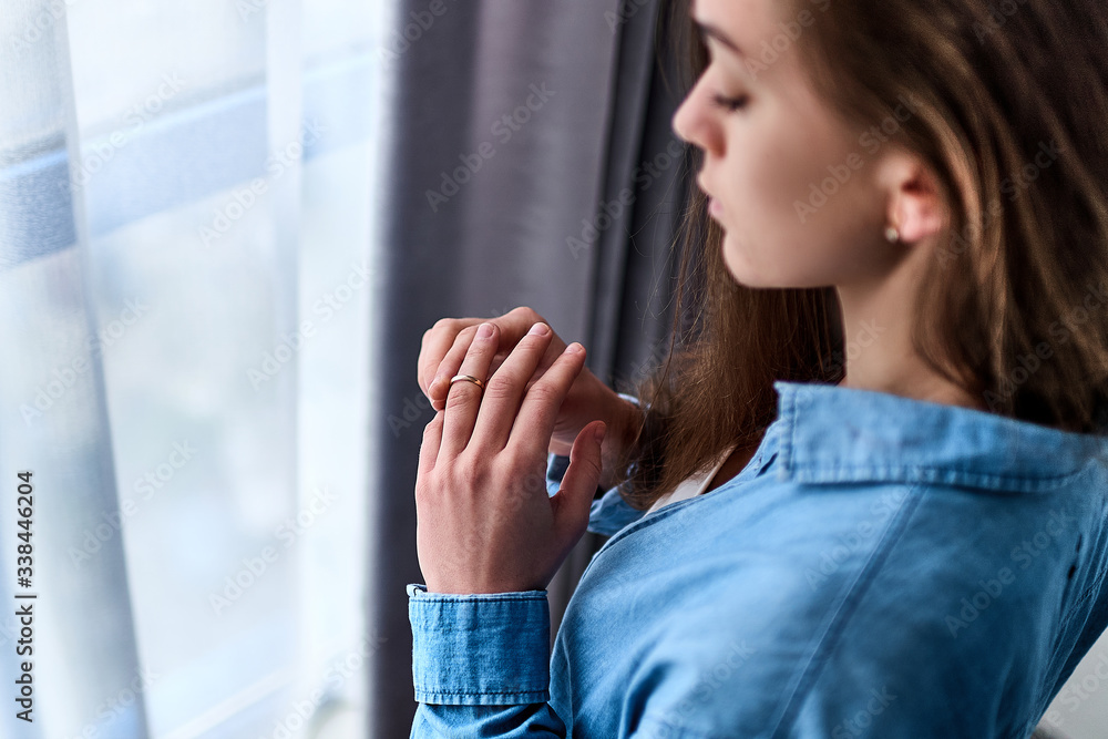 Young upset depressed lonely pensive divorced woman worrying about failed marriage and remove the ring from the finger after break up relationship and divorce