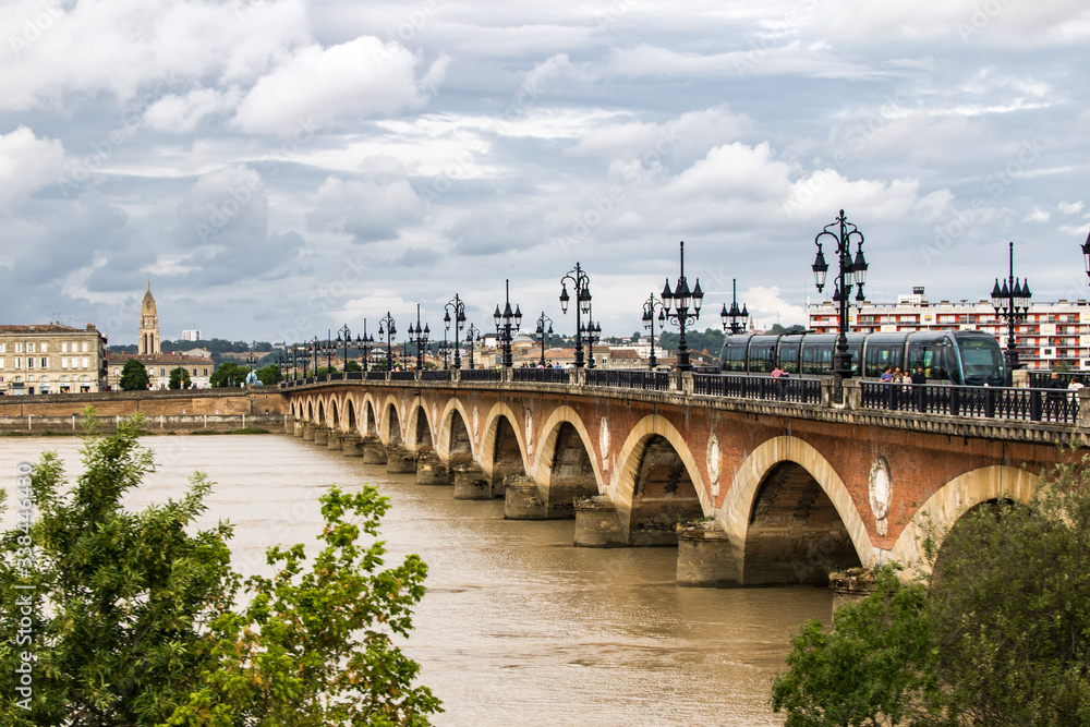 Pont de pierre traverser par le tram par un temps nuageux (Bordeaux, France)