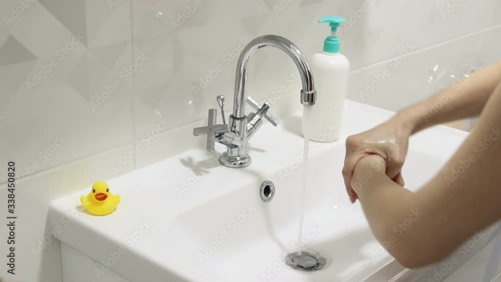 The girl washes her hands thoroughly with soap. Protect from virus The girl washes her hands thoroughly with soap. Protect from virus