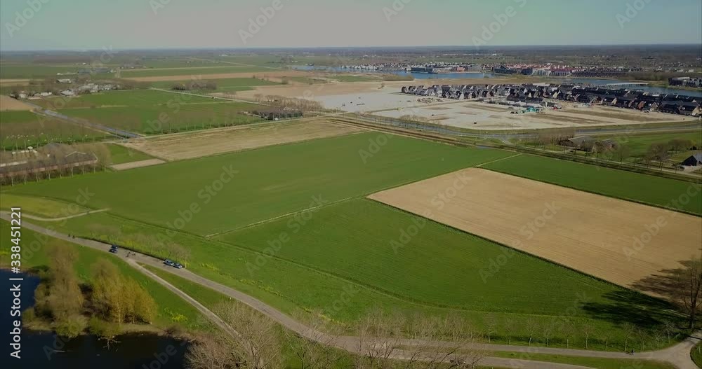 Aerial drone shot of tilt down view of the road and flat landscape with car and cyclist moving. Beautiful aerial view of the flat landscape. Aerial drone shot of tilt down view of the road and flat landscape with car and cyclist moving. Beautiful aerial view of the flat landscape.