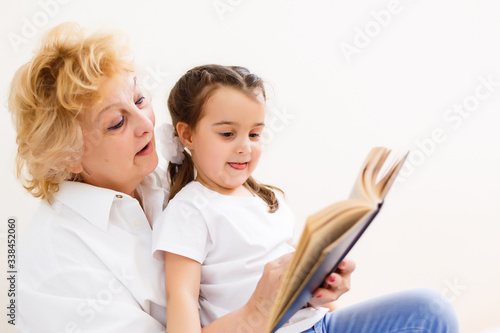 little girl with grandma reading interestng book
